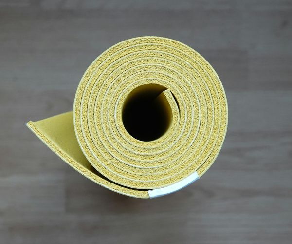 Eco-friendly yoga mat and wooden blocks on dark floor